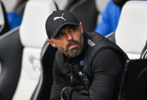 Paul Warne iført kasket kigger på under en derby-kamp.