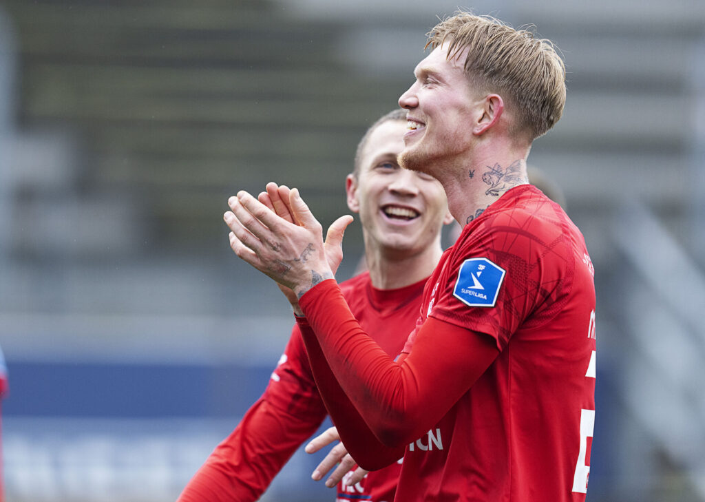 Simon MAkienok klapper i hænderne og smiler.