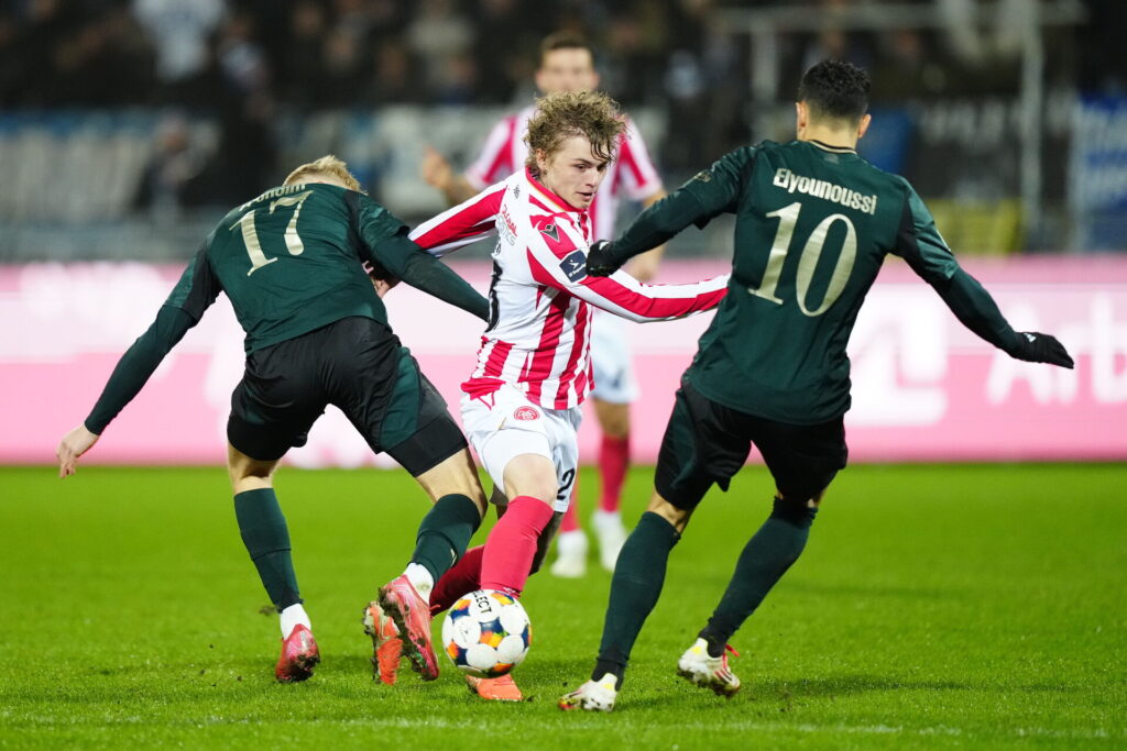 Isak Hansen-Aarøen på bolden mellem to FCK-spillere.