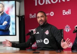 Robin Fraser taler i en mikrofon til pressemøde.