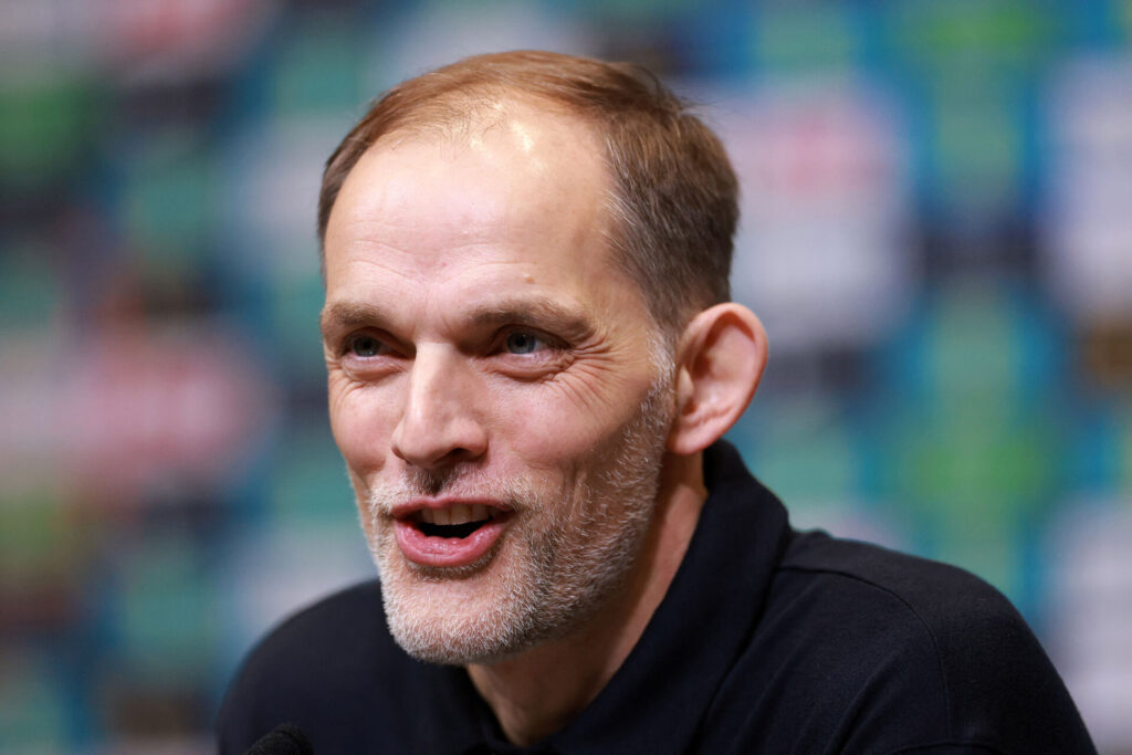 Thomas Tuchel sidder og smiler.