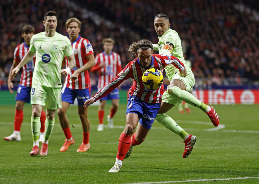 FC Barcelonas Raphinha og Atletico Madrids Antoine Griezmann i kamp om bolden.