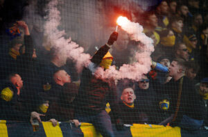 En brøndby-fan står med romerlys i hånden.