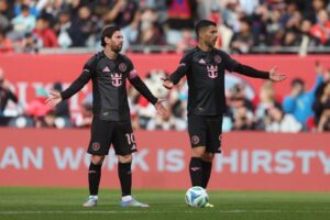 Lionel Messi og Luis Suarez slår ud med armene.