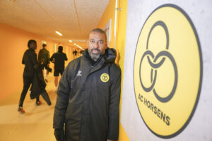 David Nielsen ved siden af et AC Horsens-logo.