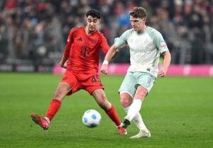 Jens Stage spiller bolden videre i en kamp mod Bayern München og Aleksandar Pavlovic.