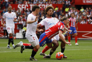 Conor Gallagher bliver tacklet af to Sevilla spillere i en kamp for Atletico Madrid.