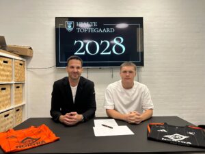 Jackie Rasmussen og Hjalte Toftegaard sidder side om side under kontraktunderskrivelse.