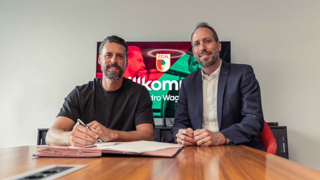 Sandro Wagner underskriver en kontrakt ved et bord.