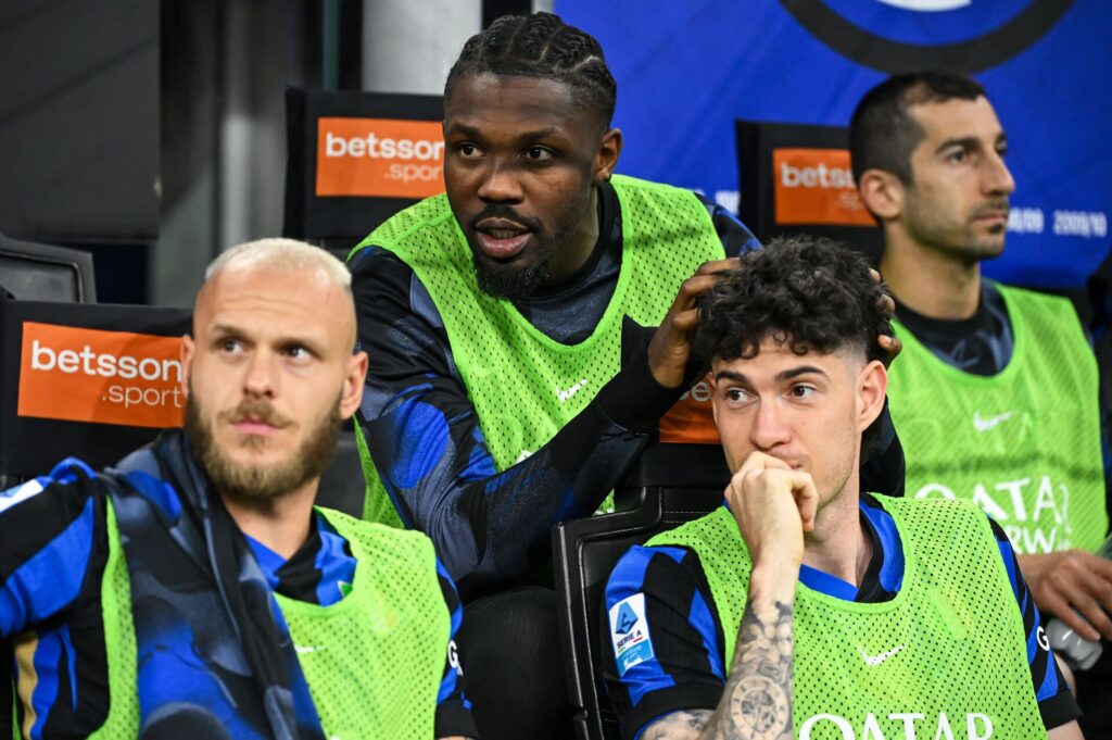 Alessandro Bastoni, Marcus Thuram og Federico Dimarco ser til fra bænken under en Inter-kamp.