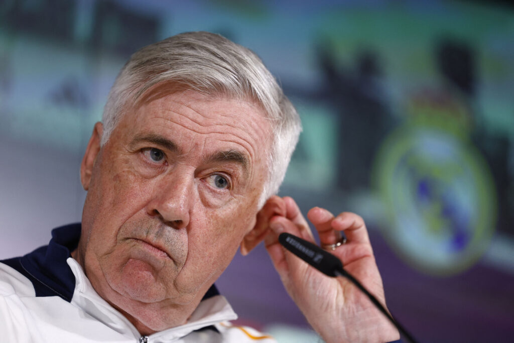 Carlo Ancelotti med en mikrofon piller ved sit øre.
