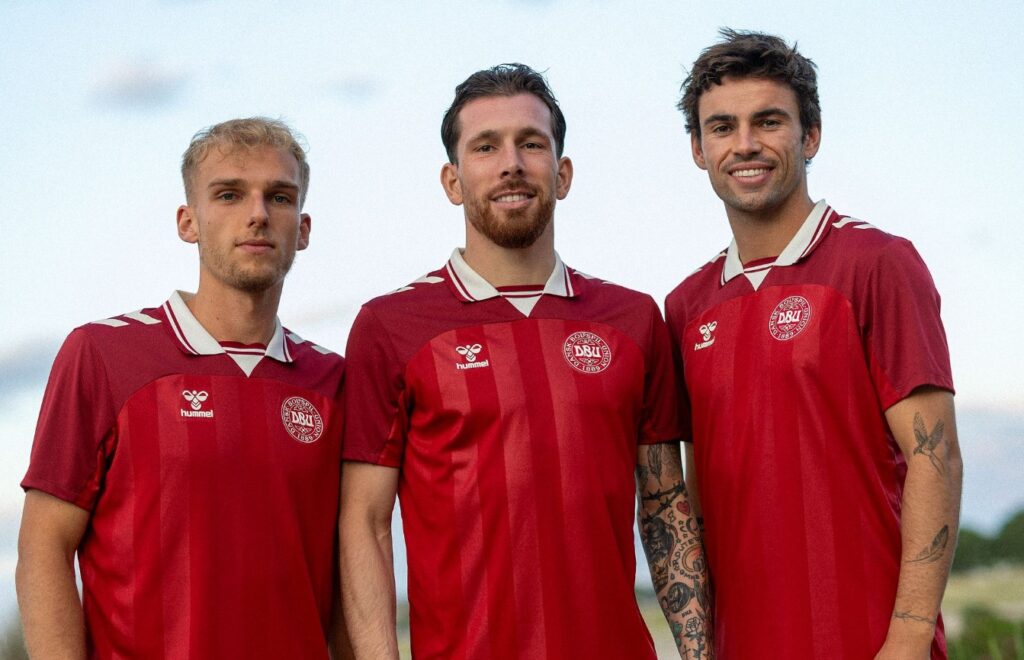Gustav Isaksen, Pierre Emile Højbjerg og Matt O'Riley poserer i kvindelandsholdets trøjer.