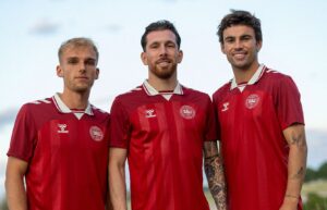 Gustav Isaksen, Pierre Emile Højbjerg og Matt O'Riley poserer i kvindelandsholdets trøjer.