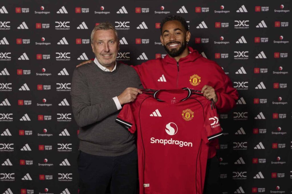 Jason Wilcox og Matheus Cunha holder sammen en Manchester United trøje.