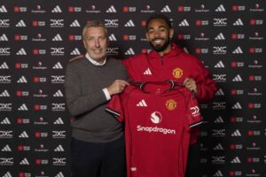 Jason Wilcox og Matheus Cunha holder sammen en Manchester United trøje.