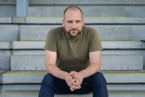 Nicas Kjeldsen sidder på en trappe med samlede hænder.