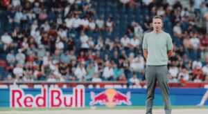 Pepijn Lijnders står med hænderne bag ryggen på græsset.