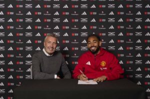 Matheus Cunha underskriver sin kontrakt med Manchester United sammen med Fodbolddirektør James Wilcox