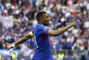 Kylian Mbappé peger ud mod stadion.