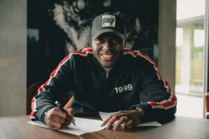 Edward "Chili" Chilufya skriver under på en kontrakt med et stort smil.