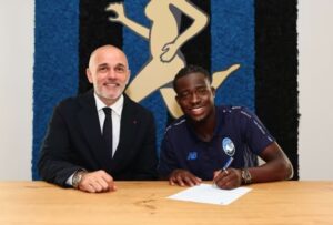 Kamaldeen Sulemana skriver under på et stykke papir.