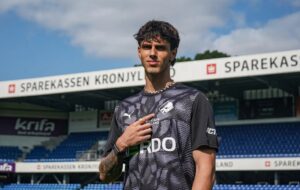 Mert Demirci peger på Randers-logoet på sit bryst.