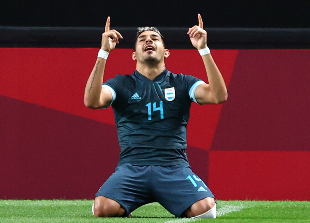 Medina peger med begge fingre mod himlen.