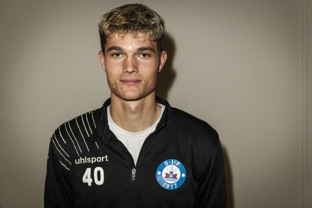 Alexander Busch står op ad en væg