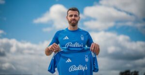 Angus Gunn står med en Nottingham Forest-trøje i sine hænder.