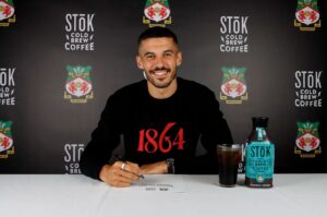Conor Coady med et stort smil ved at skrive under på kontrakt i Wrexham.