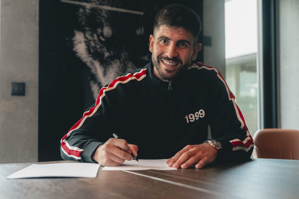 Martin Erlic skriver under på en kontrakt i FCM