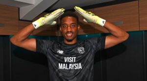Nathan Trott med to hænder over hovedet ved sin præsentation i Cardiff City.