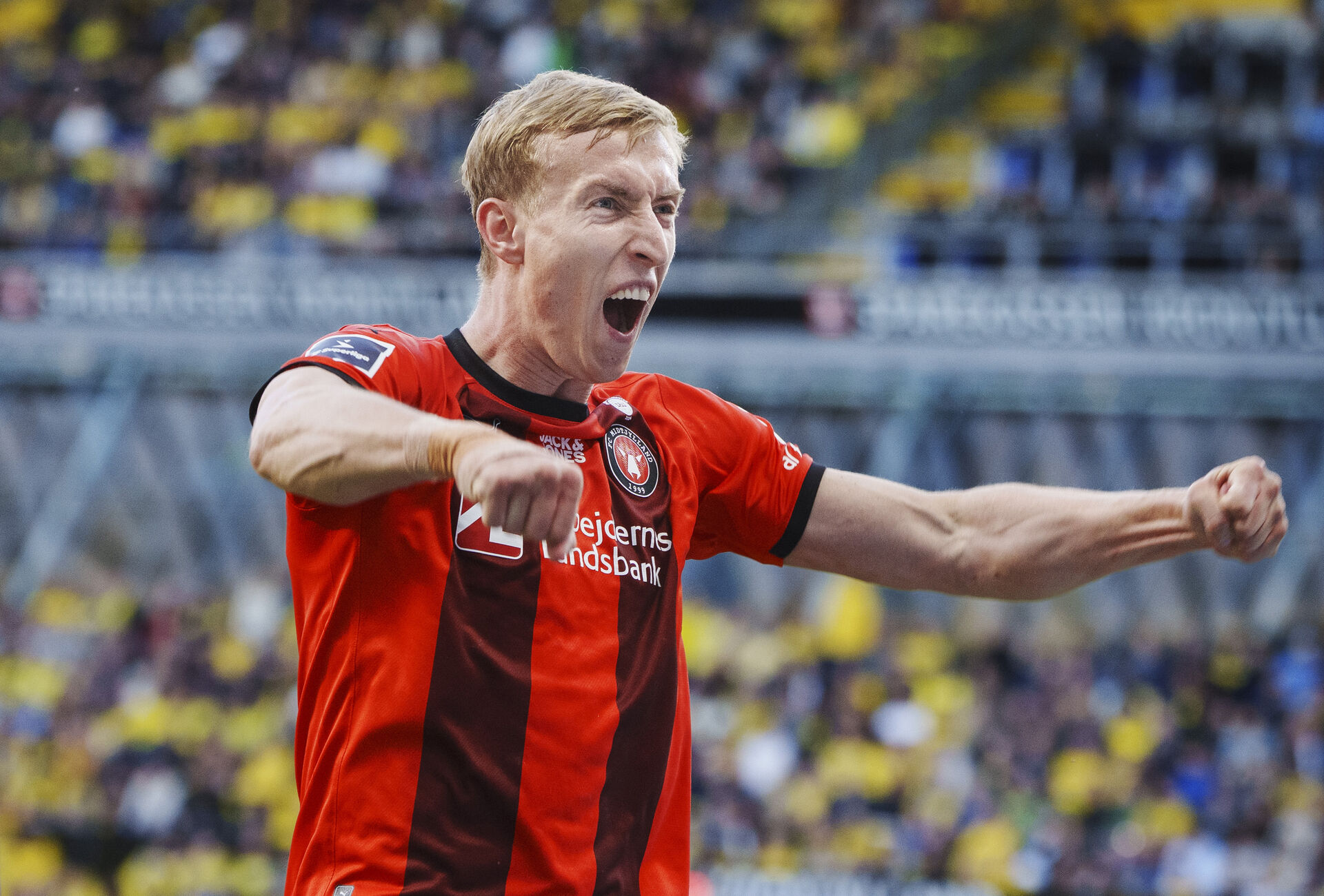 Adam Buksa jubler med armene ud til siden og åben mund.