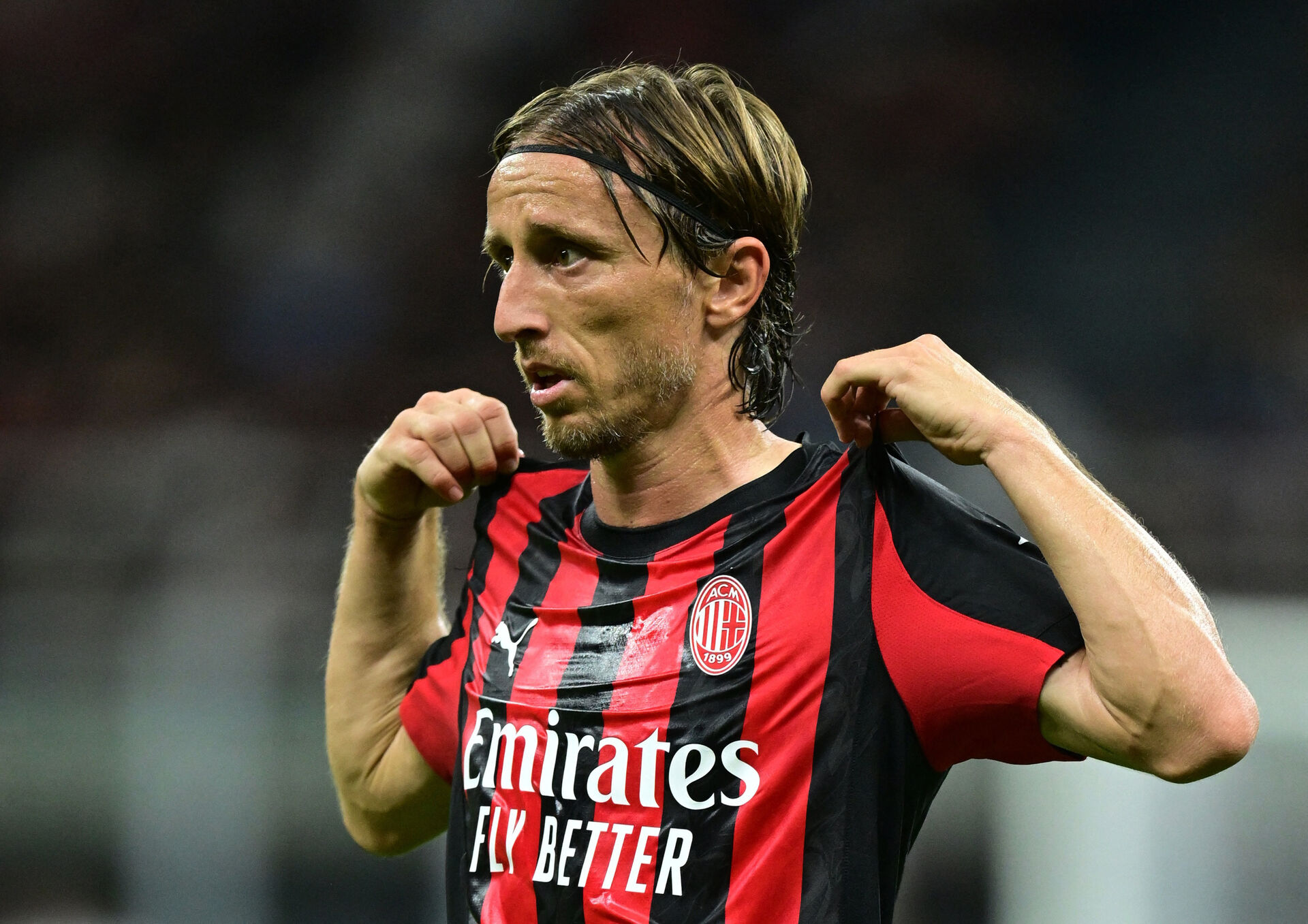 Luka Modric retter på sin trøje under en kamp for AC Milan