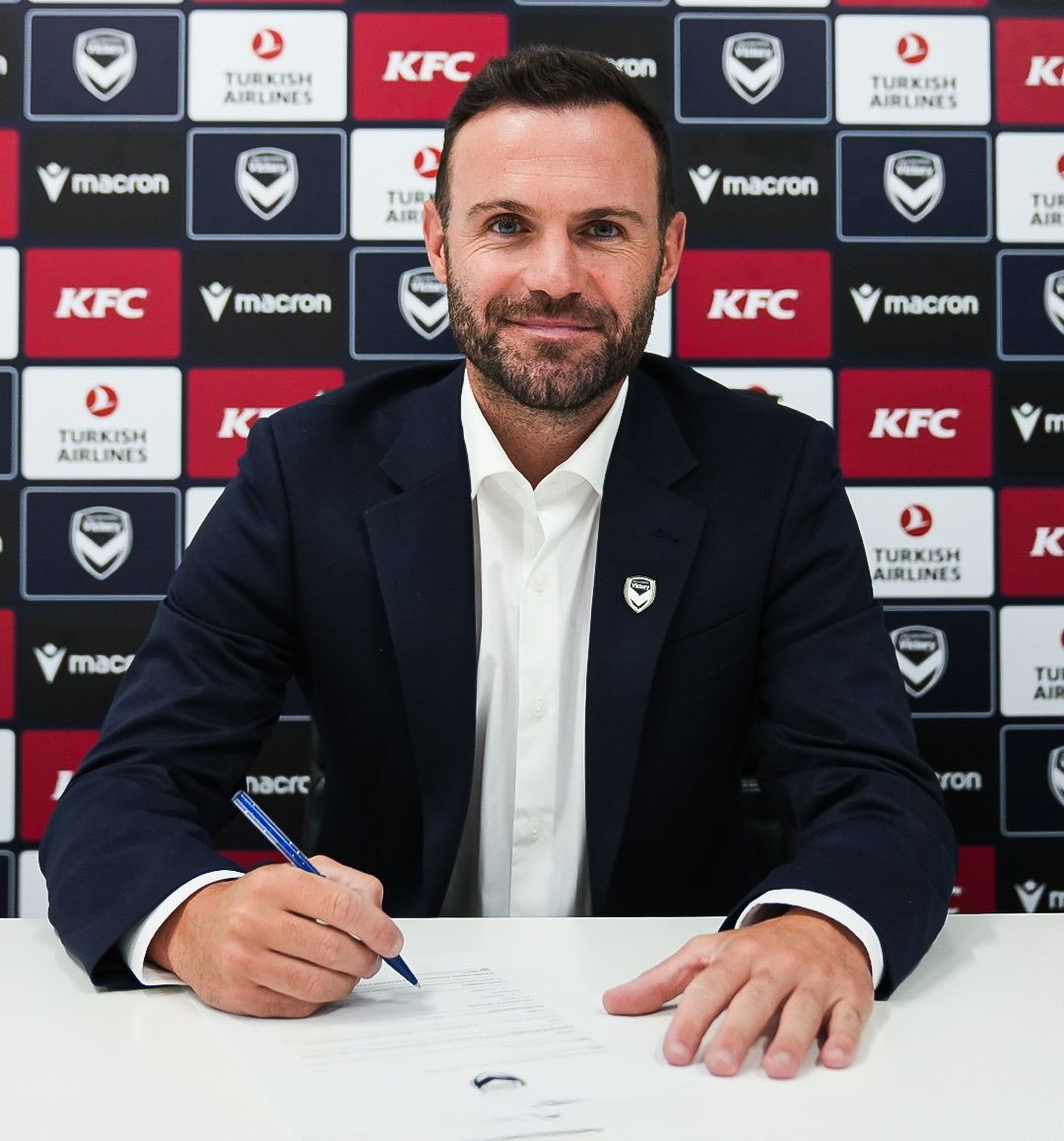 Juan Mata sidder ved et bord med en kuglepen i hånde og en kontrakt foran sig.