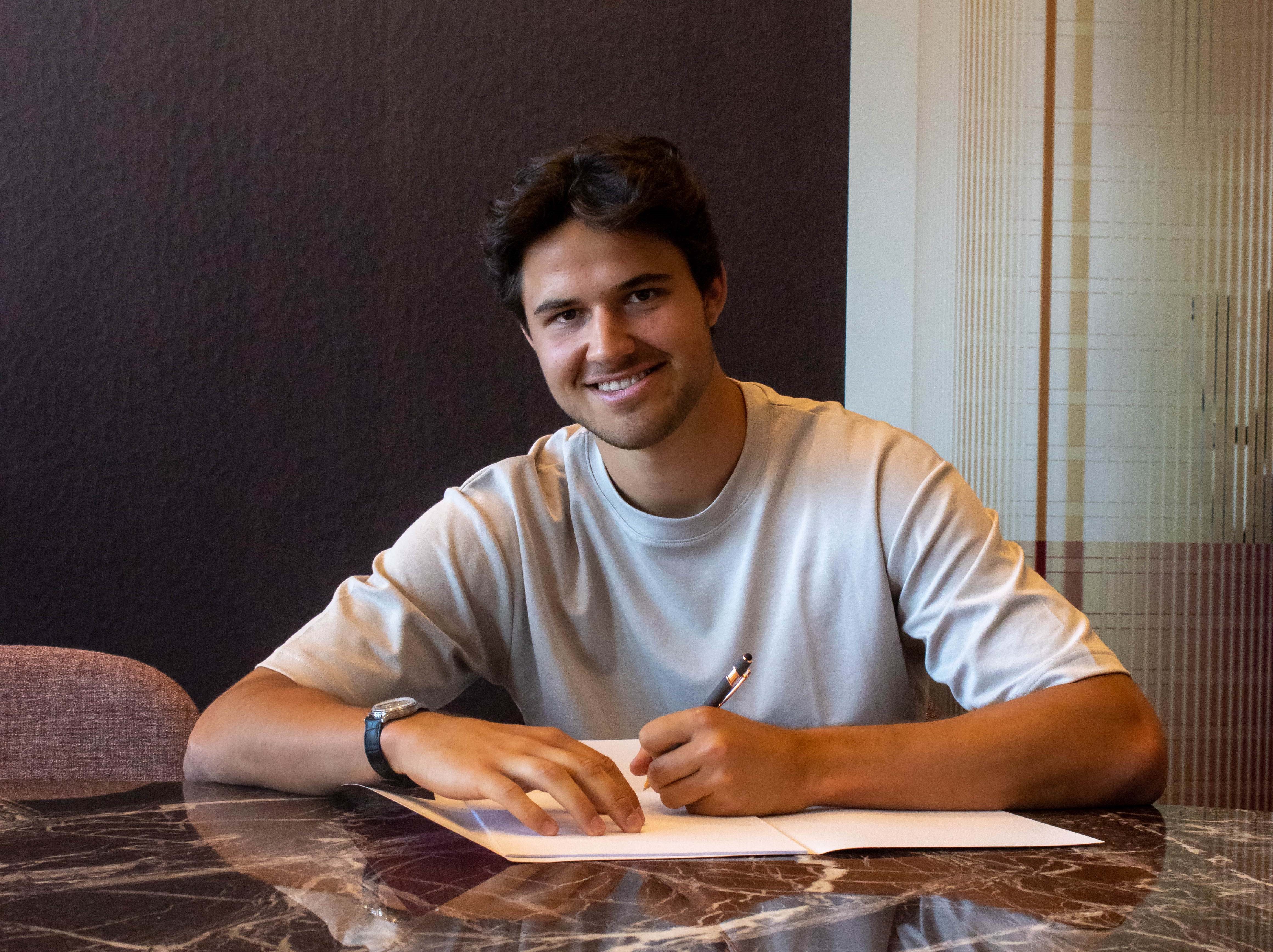 Senne Lammens skriver under på en kontrakt.