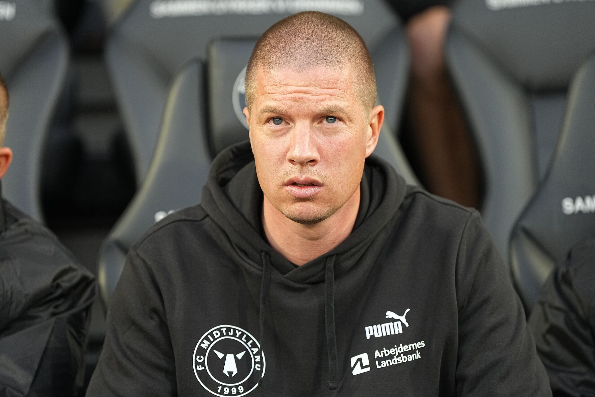 Mike Tullberg kigger ud på banen på bænken for FC Midtjylland.