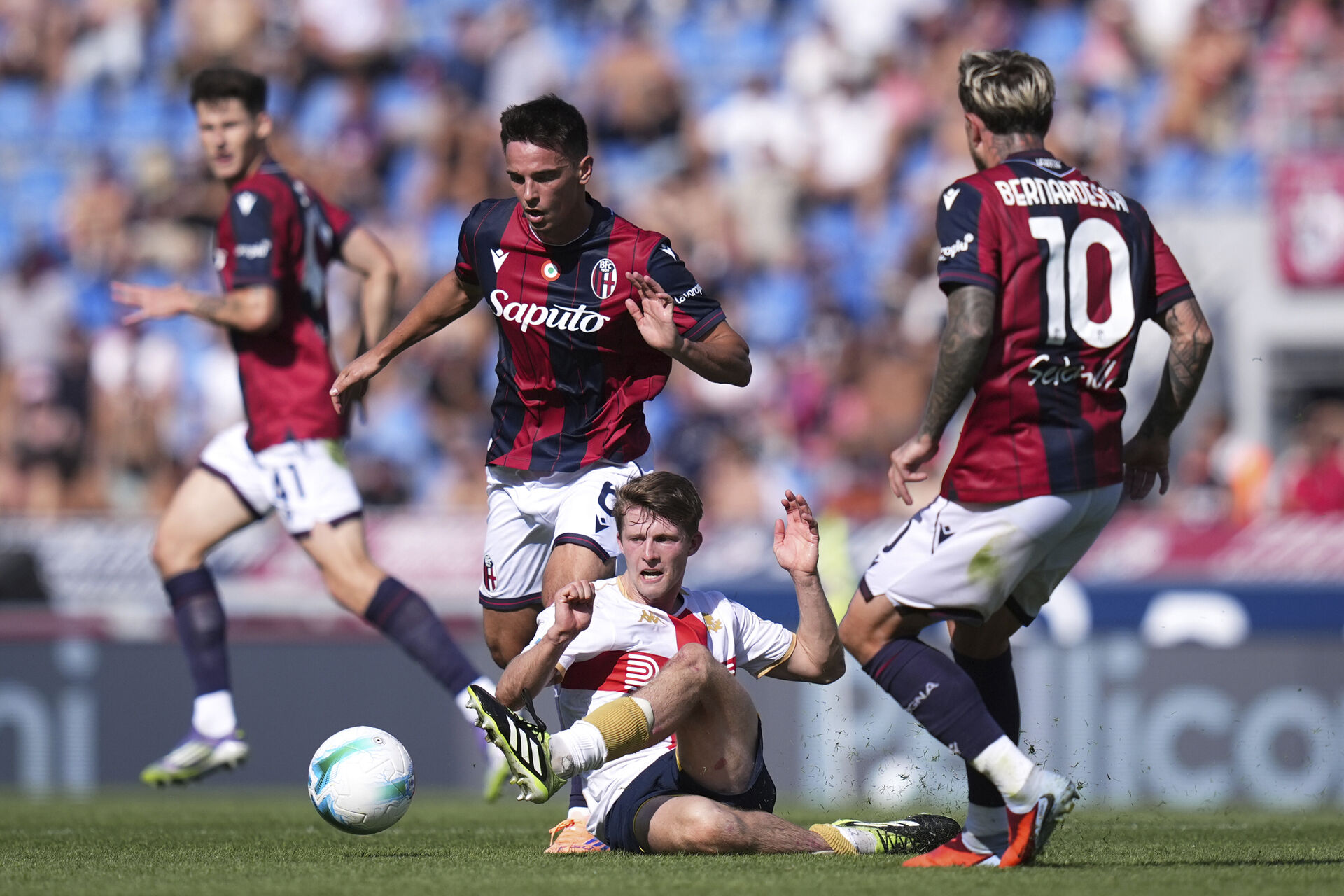 Morten Frendrup ligger på jorden mellem to Bologna-spillere.