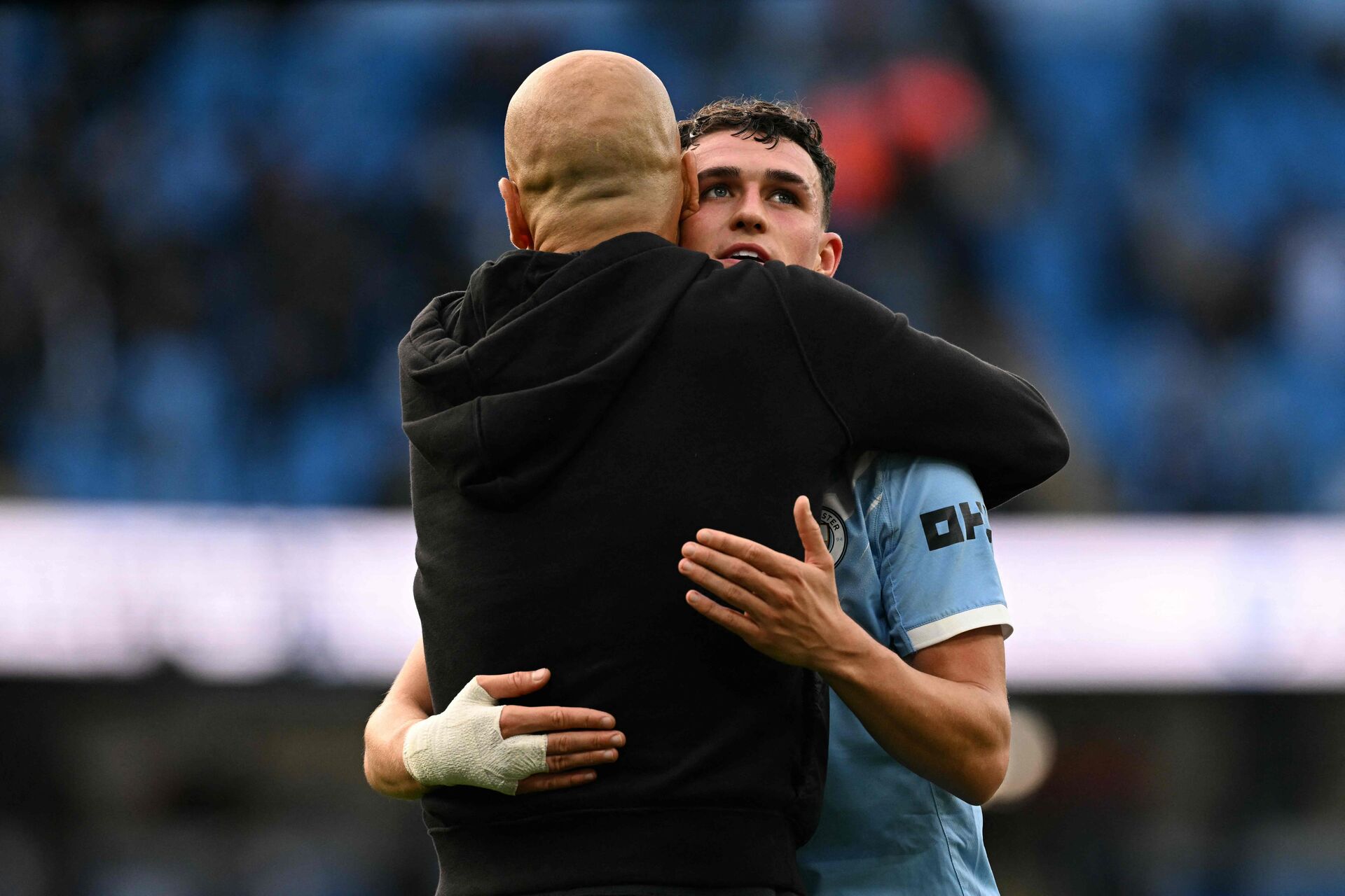 Manchester Citys Phil Foden krammer cheftræner Pep Guardiola.