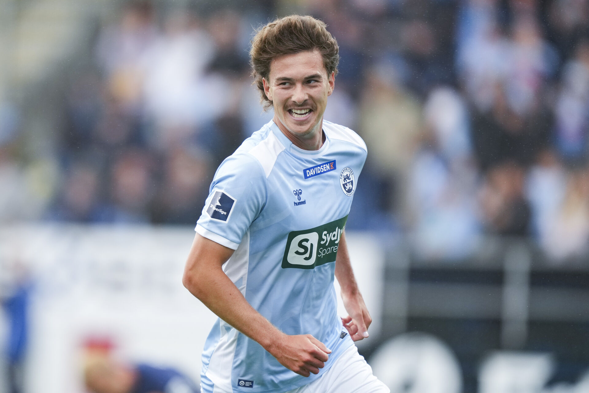 Hoppe smiler, mens han løber.