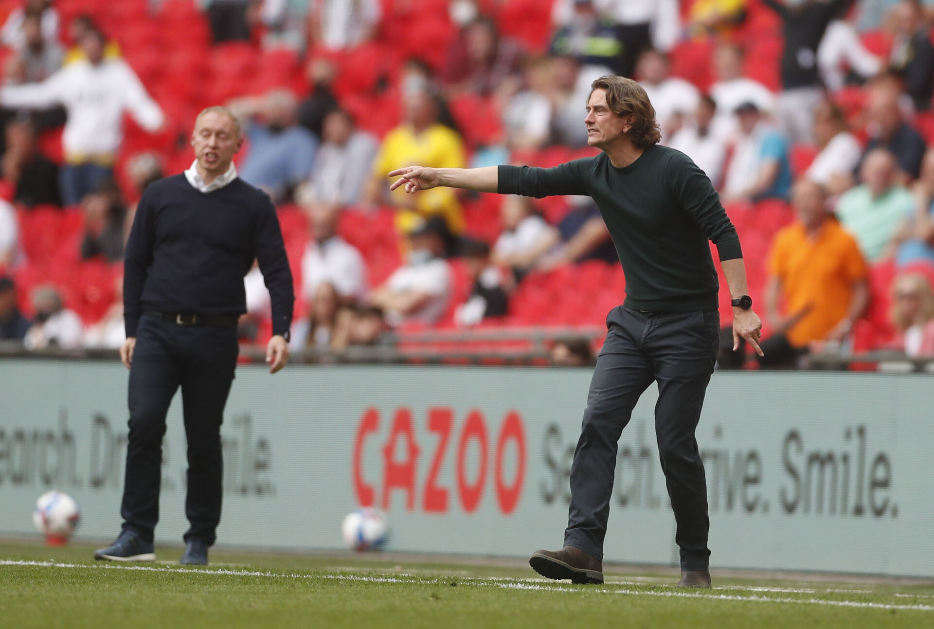 Thomas Frank dirigerer på Wembley med Steve Cooper i baggrunden.