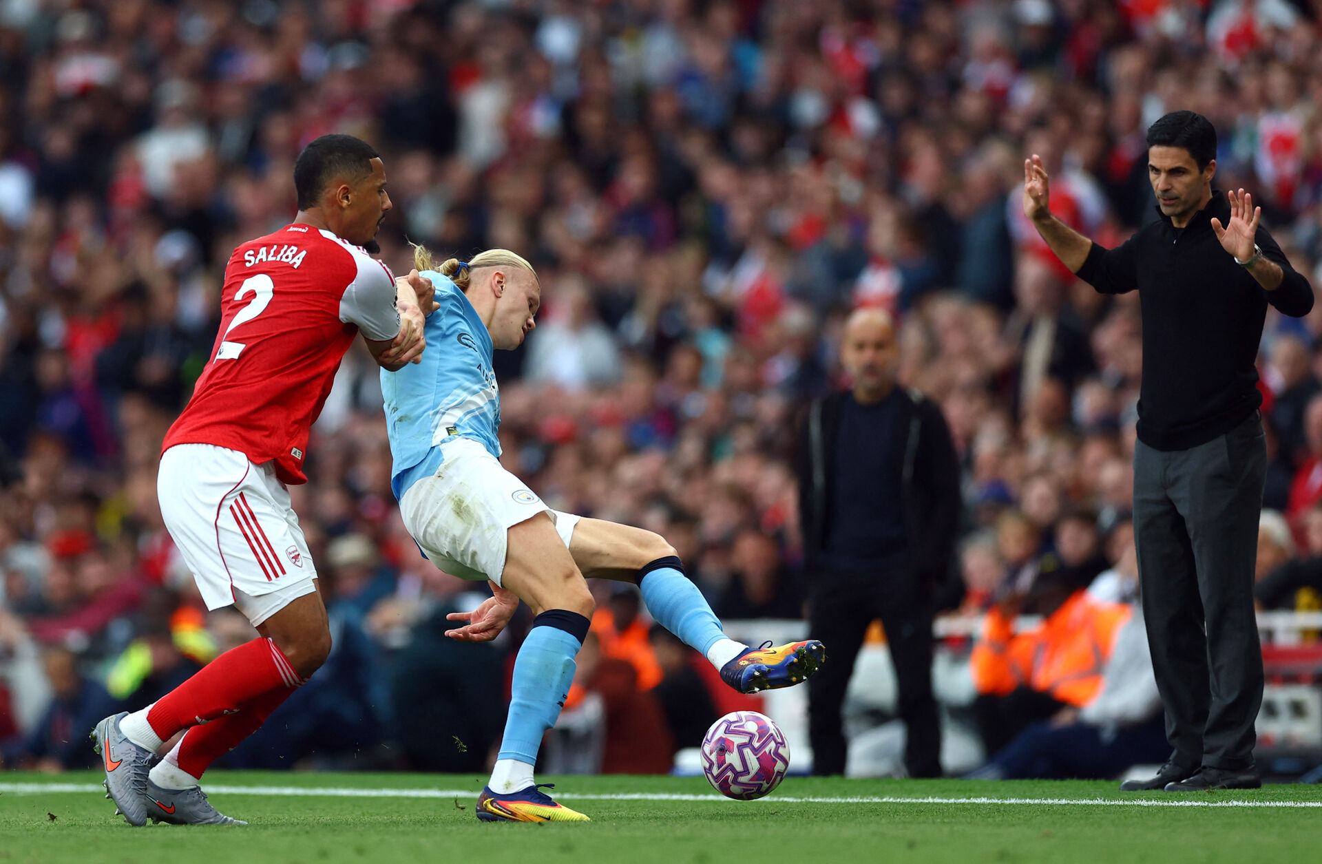 Erling Haaland skærmer bolden mod Arsenal.