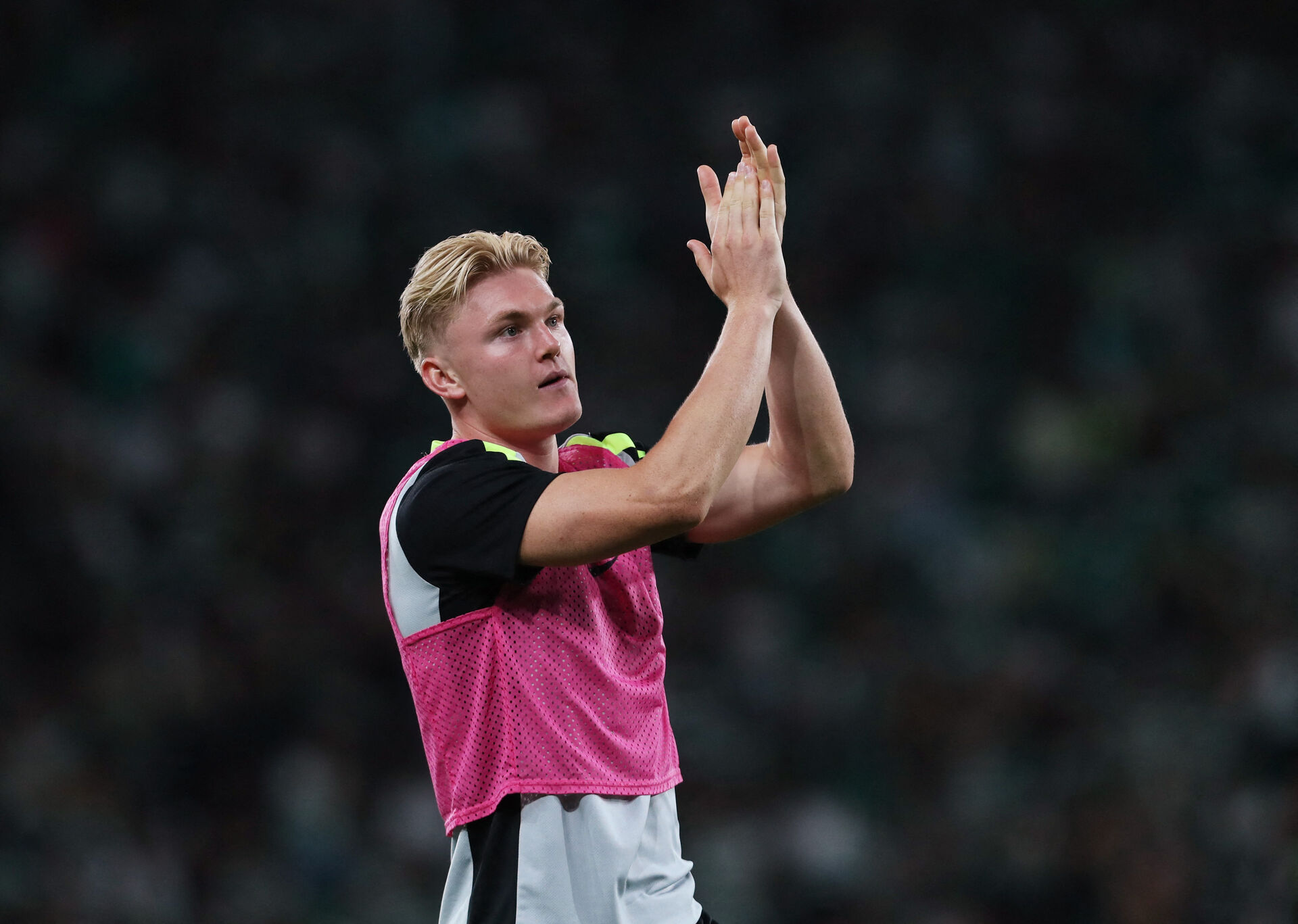 Conrad Harder klapper ud til fansene, mens han har en overtræksvest på.