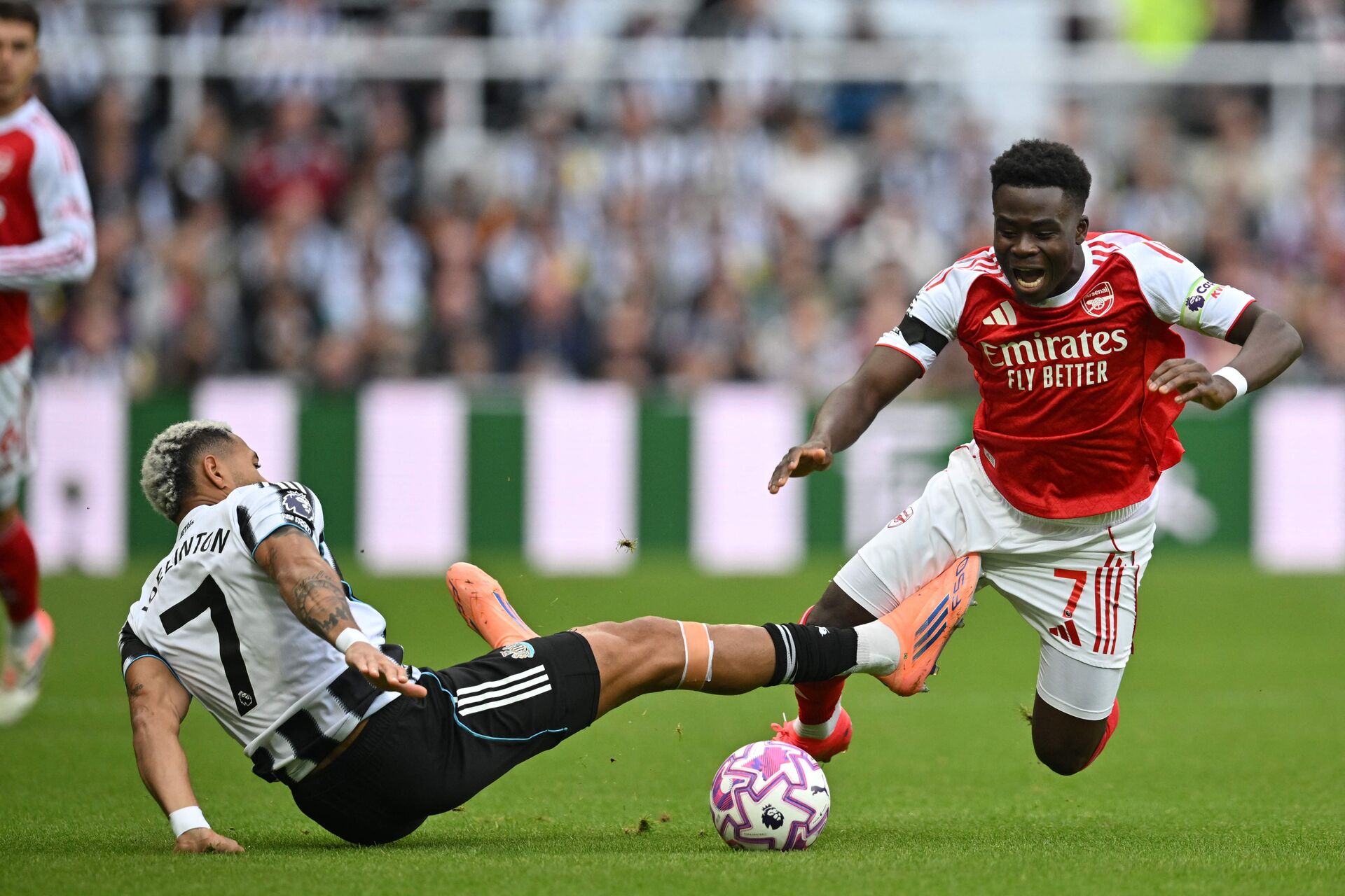 Bukayo Saka ved at blive tacklet.