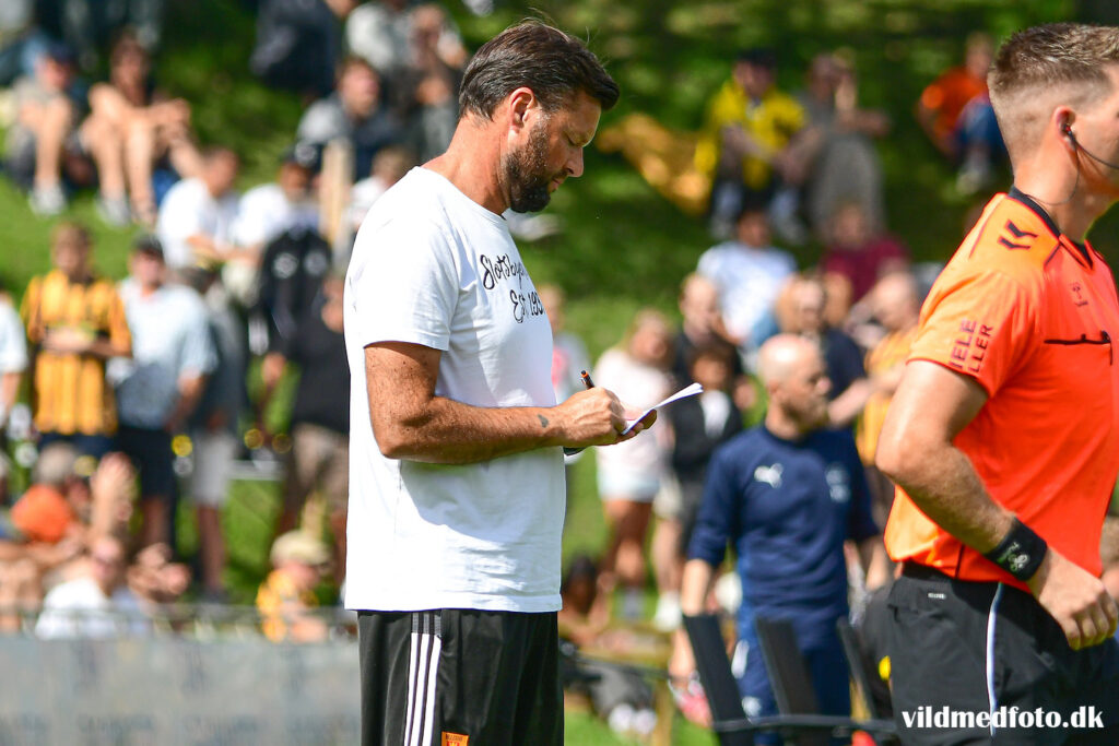 Christian Lønstrup noterer sig noget i sin notesbog.