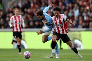 Kevin Schade kæmper om bolden mod Manchester City.