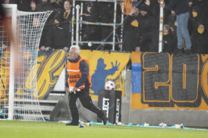 En vagt fjerner nogle bamser, nogle Brøndby-fans har smidt på banen.