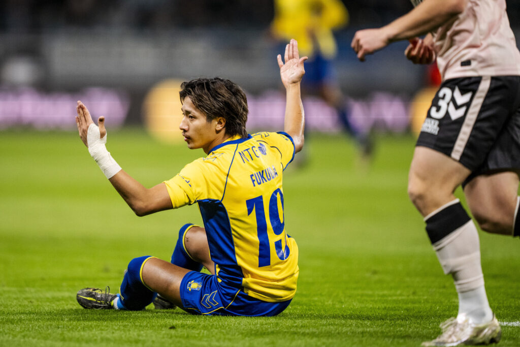 Sho Fukuda sidder på græstæppet på Brøndby Stadion.