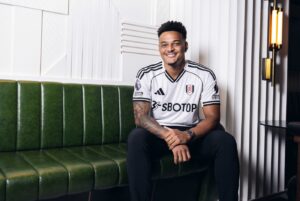 Rodrigo Muniz sidder på en grøn sofa og smiler.