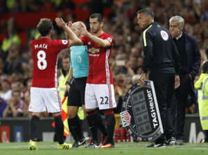 Jose Mourinho ser til, mens Henrikh Mkhitaryan og Juan Mata skiftes under en Manchester United-kamp
